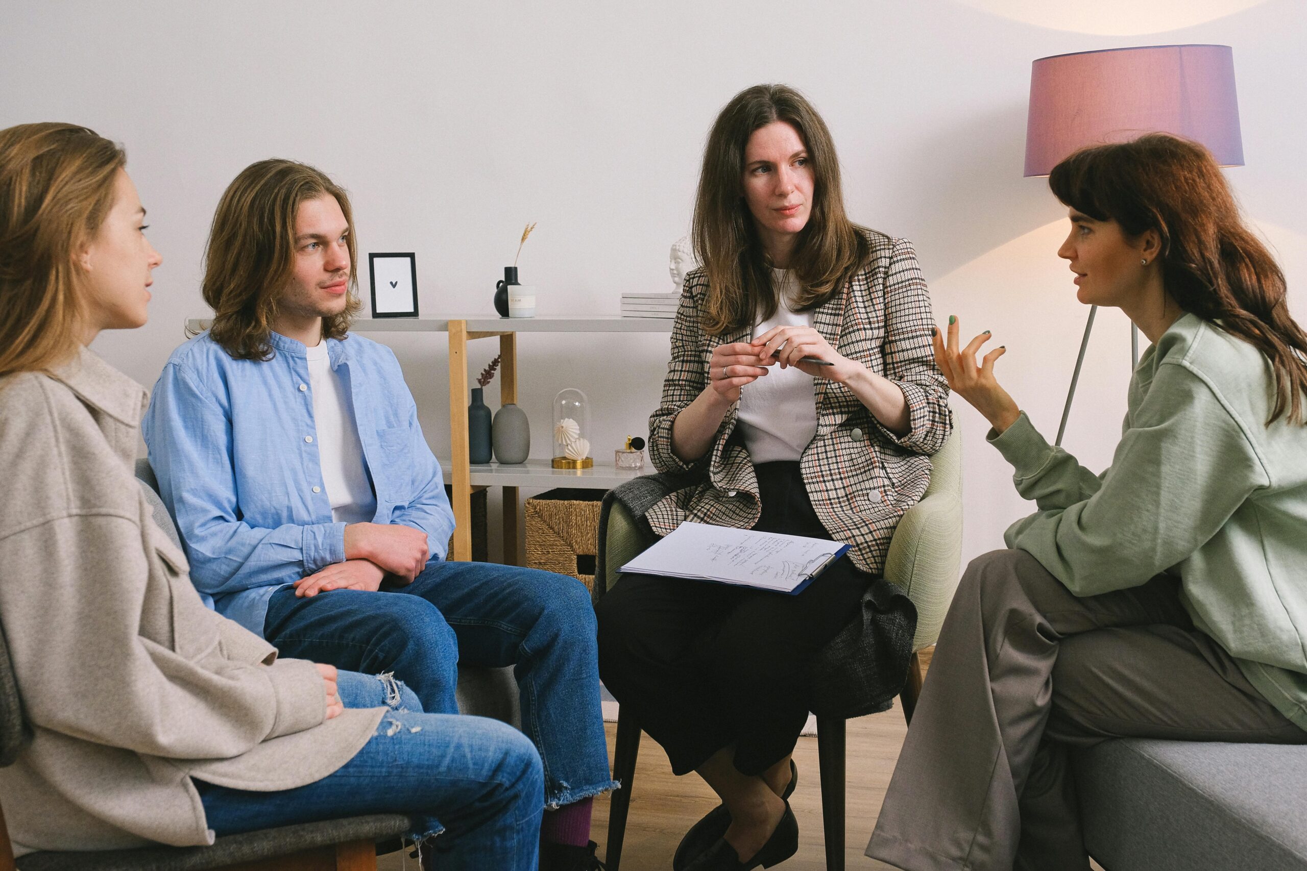 Image of three people sitting in circle with group therapy therapist.