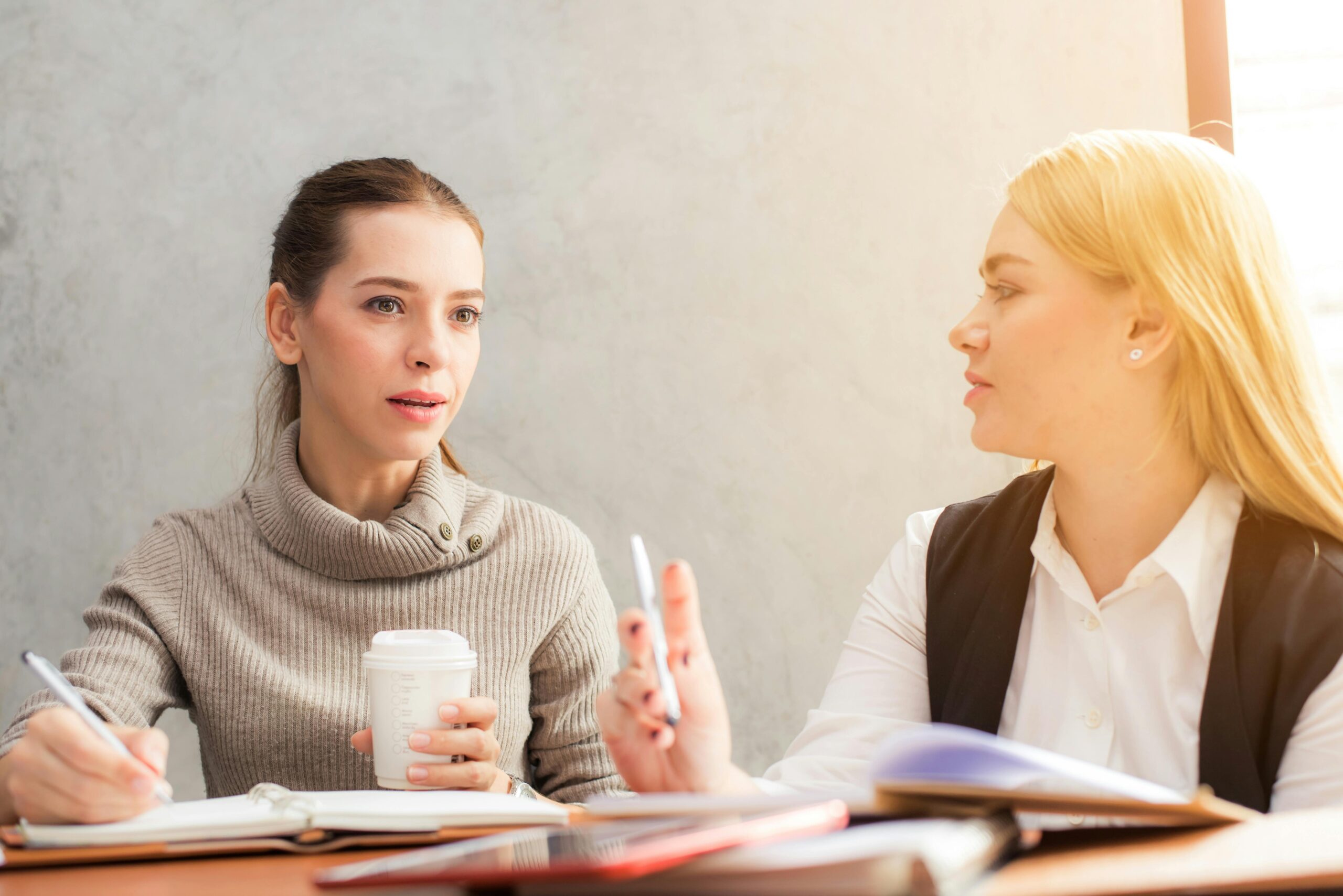 Two business people talking together in a meeting.