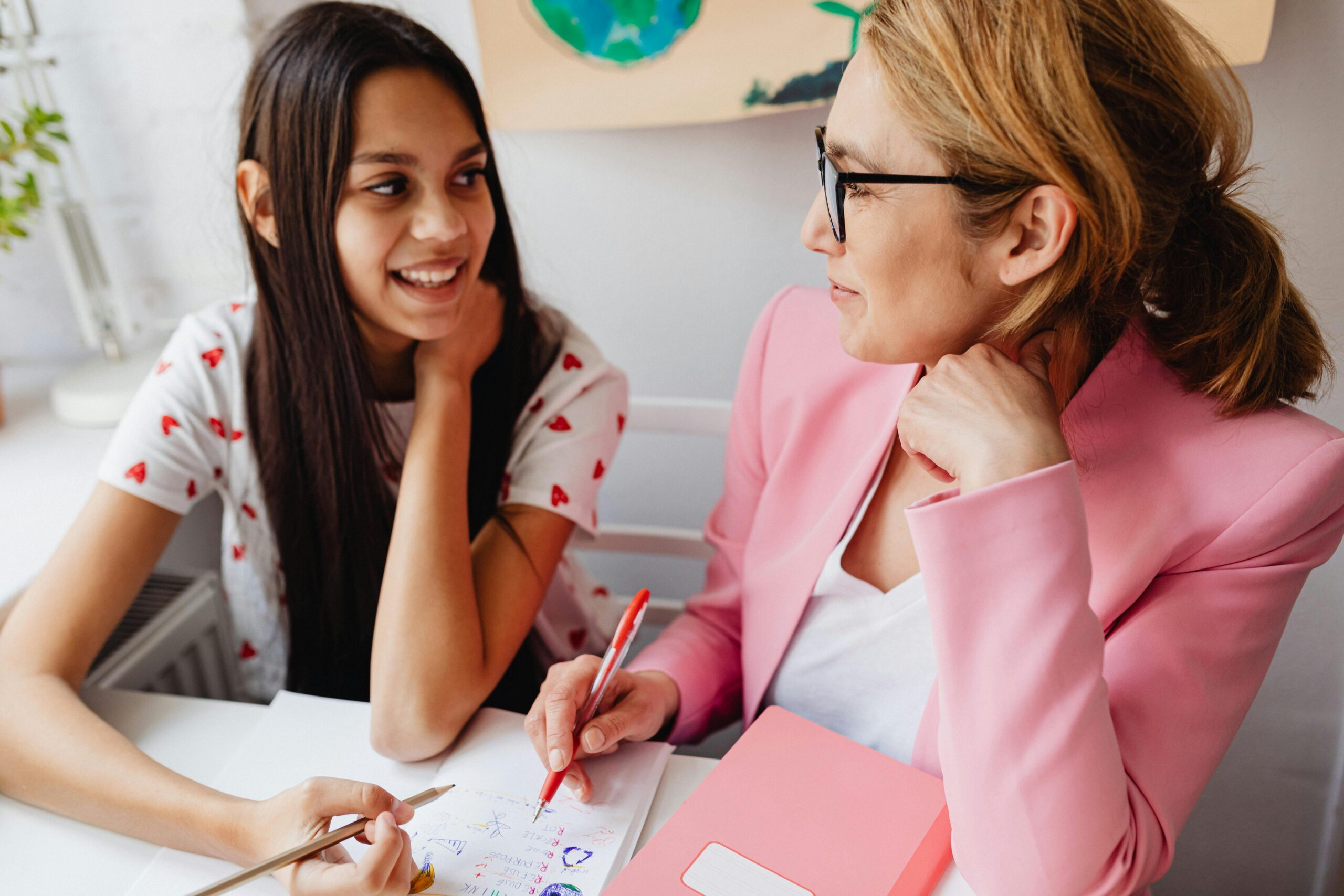 Image of teen child working in therapy with therapist through journaling in journal.