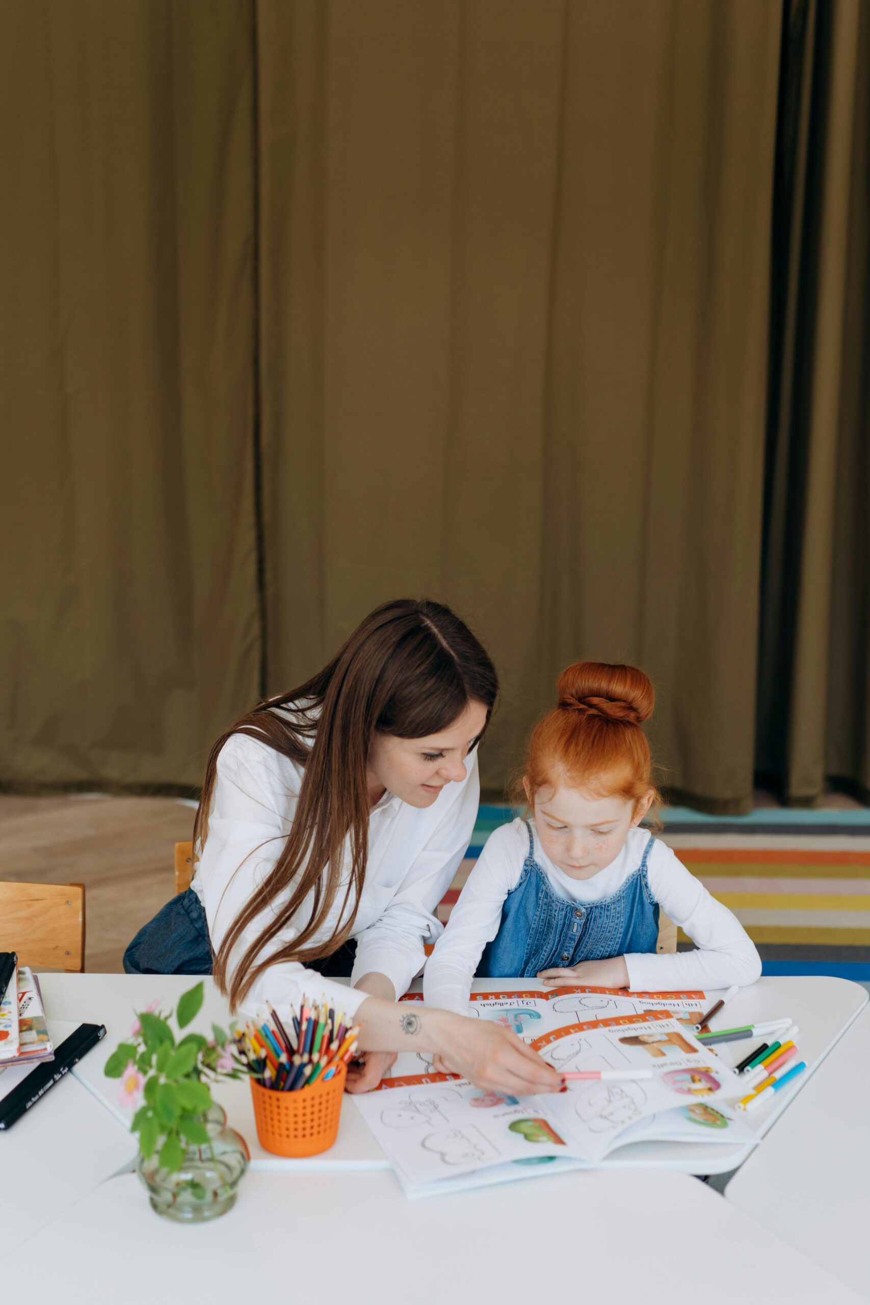 Image of female therapist working with young child in therapy through coloring.
