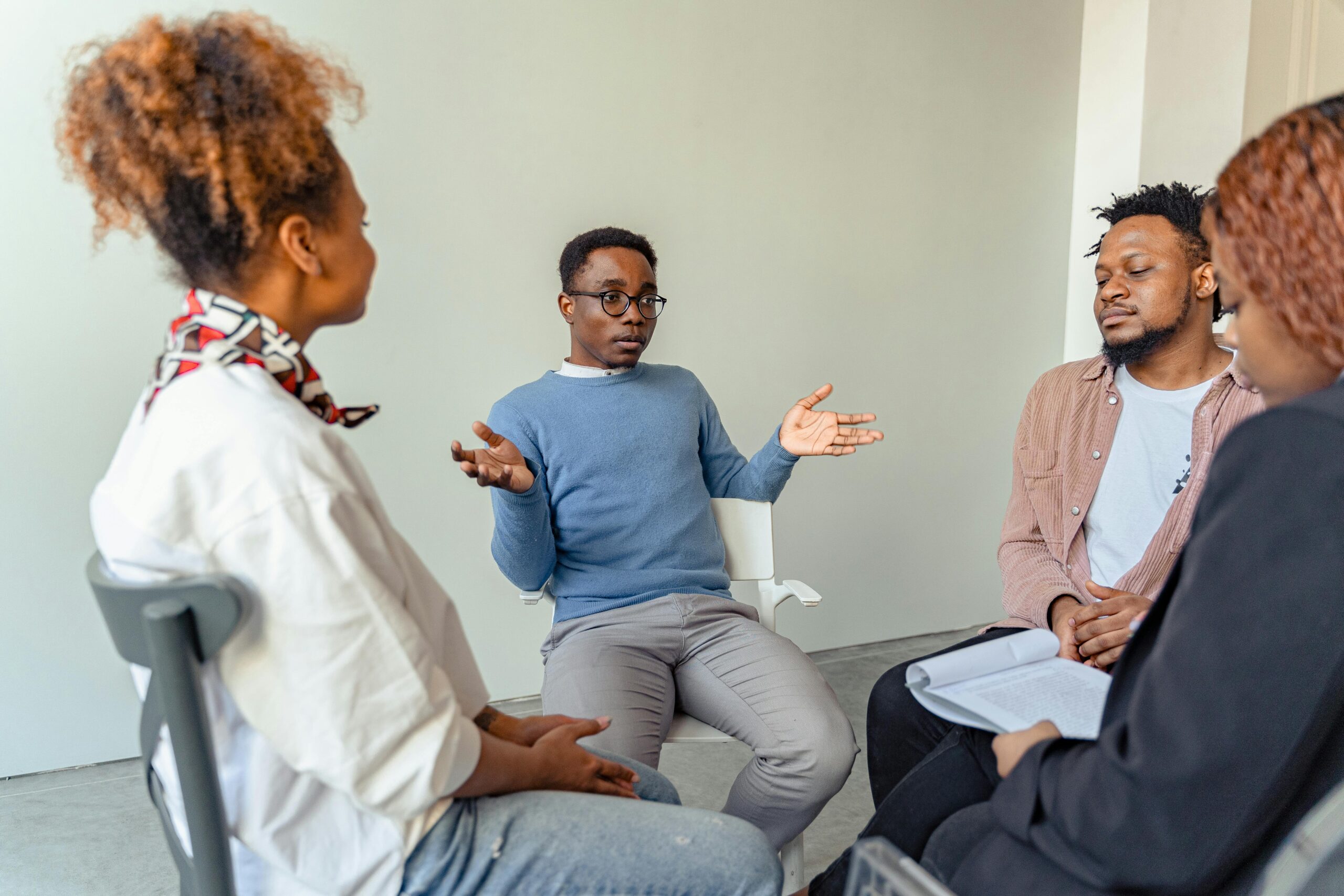 Image of group therapy participant expressing hand gestures to make statement in the group discussion.