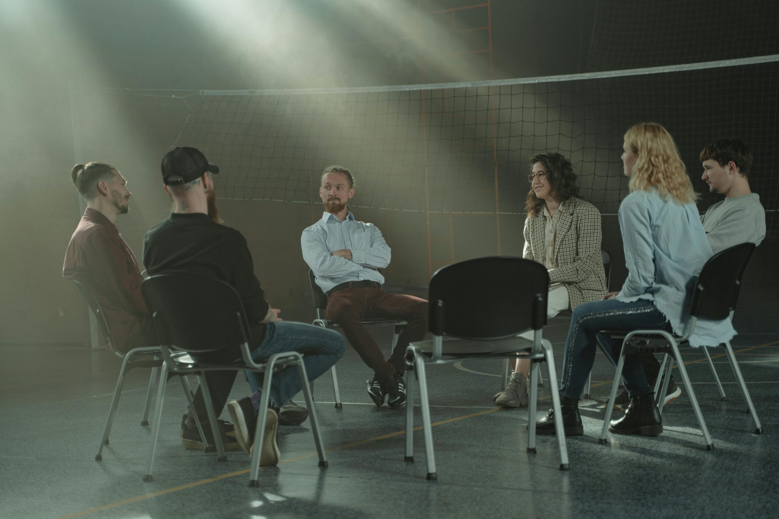 Image of six people sitting in a circle with one another.