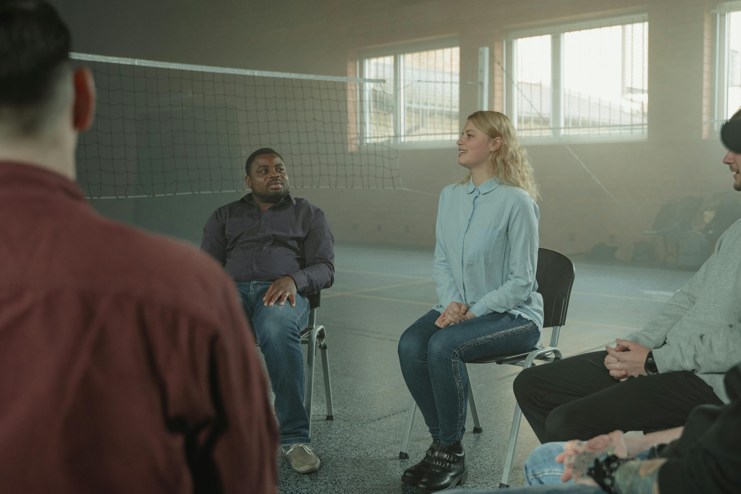 Image of four people sitting in circle and conversing with one another.