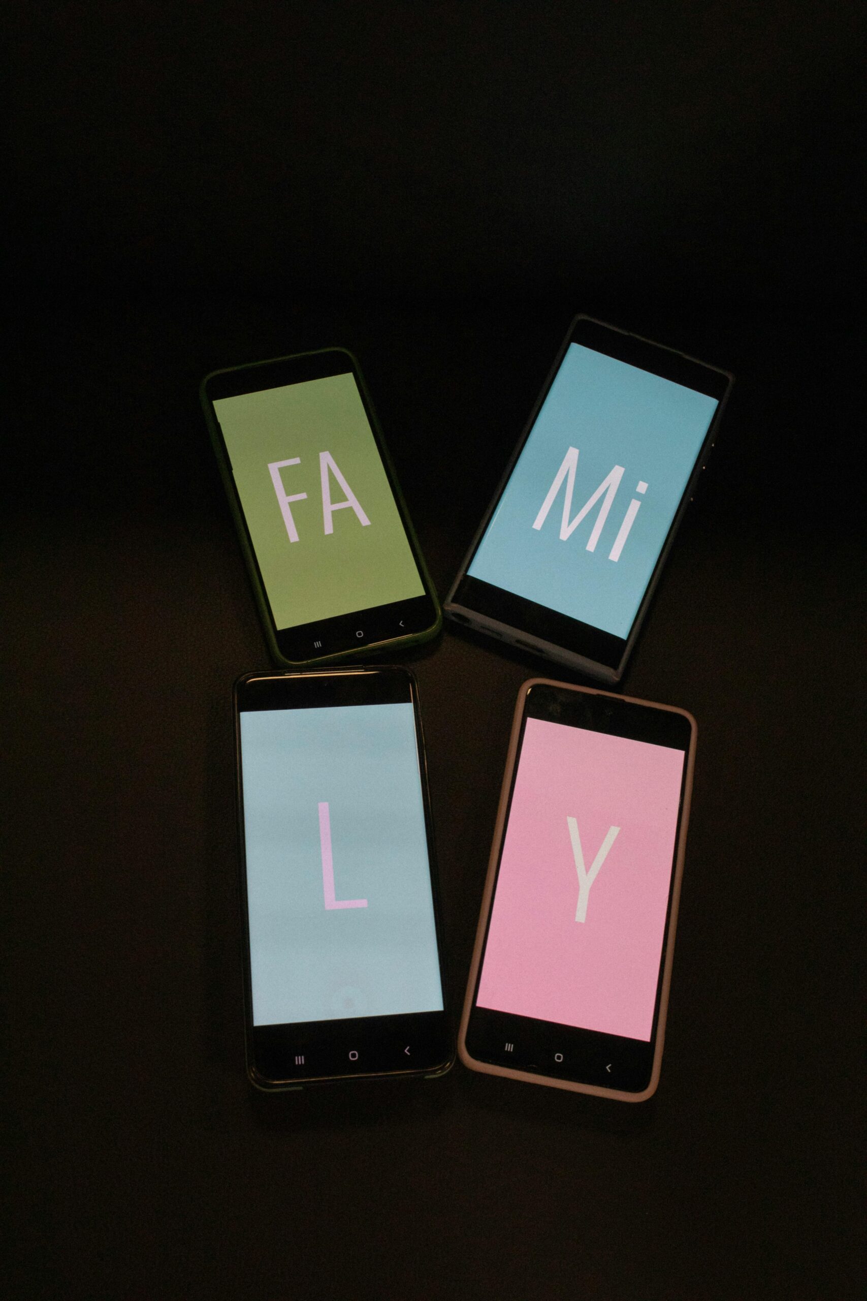 Image of four cell phones with the letters, "FA, Mi, L, Y" spelled on the various phones to make the word, "Family" when placed together.