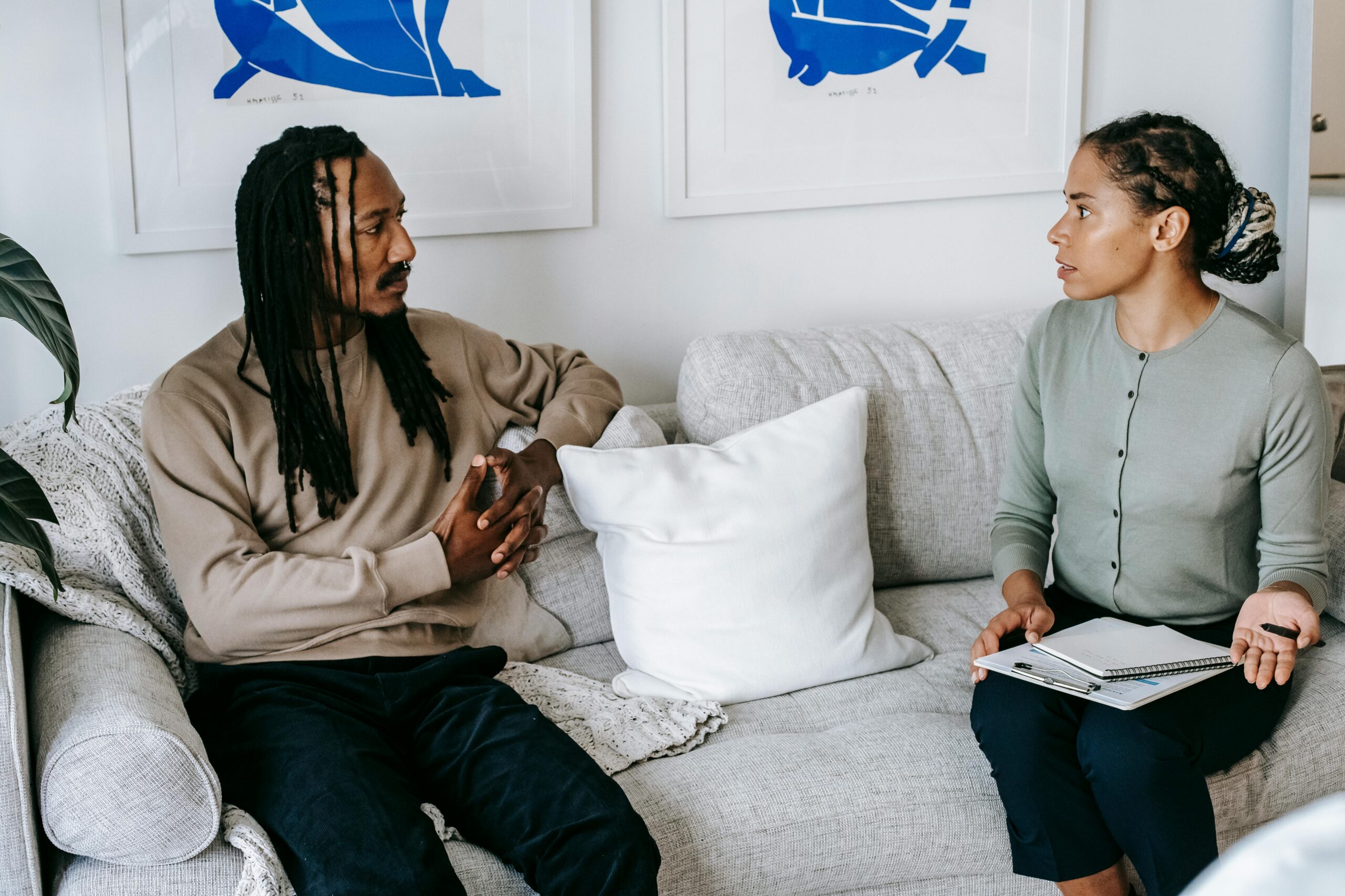 Image of therapist and entertainer sitting on couch doing therapy together.