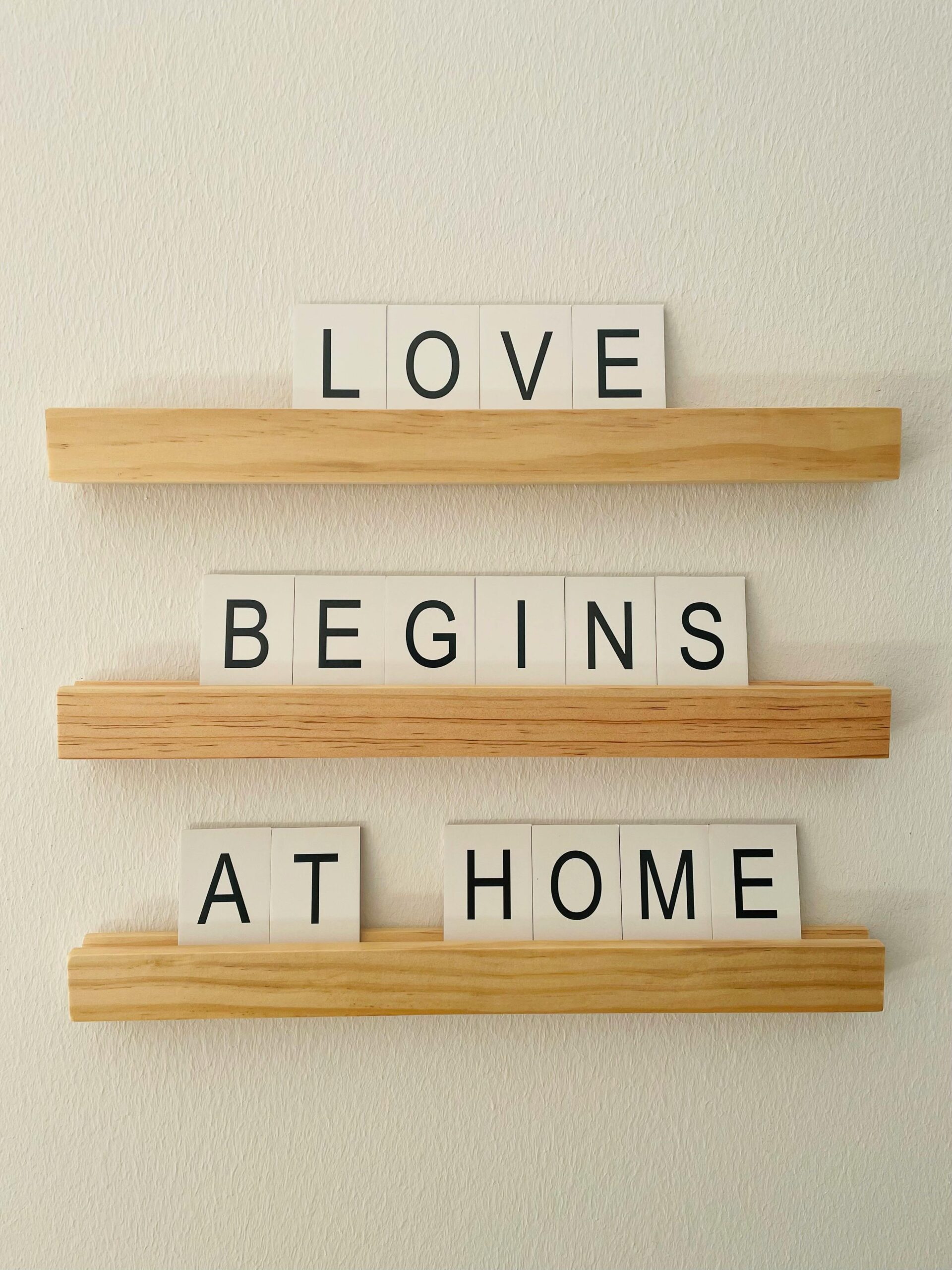 Image of tiles on a board that spell out the words, "Love begins at home."