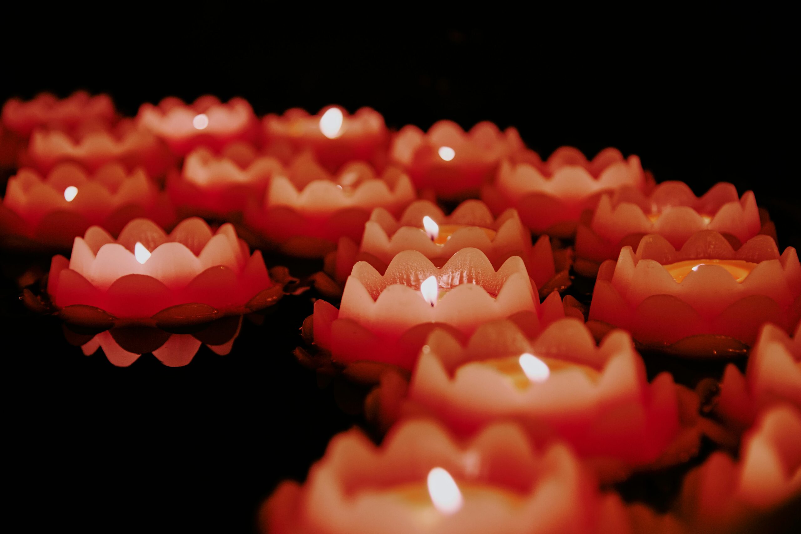 Image of candles lit in the shape of flowers.